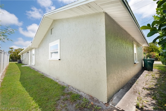 view of home's exterior with central AC unit and a lawn