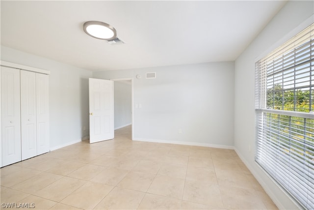 unfurnished bedroom with a closet and light tile flooring