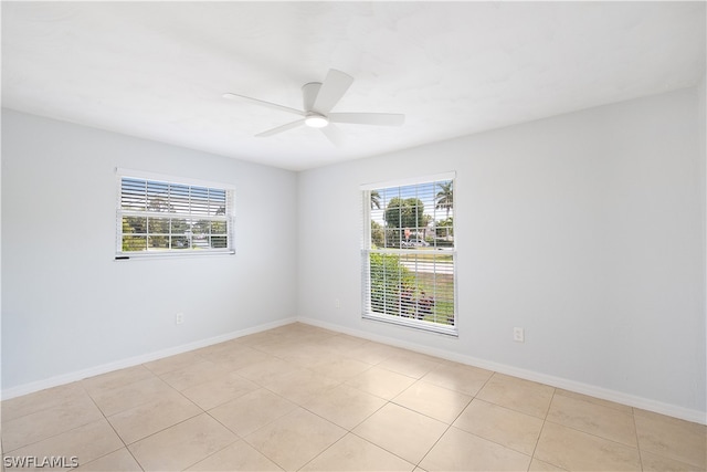 tiled spare room with ceiling fan and a wealth of natural light