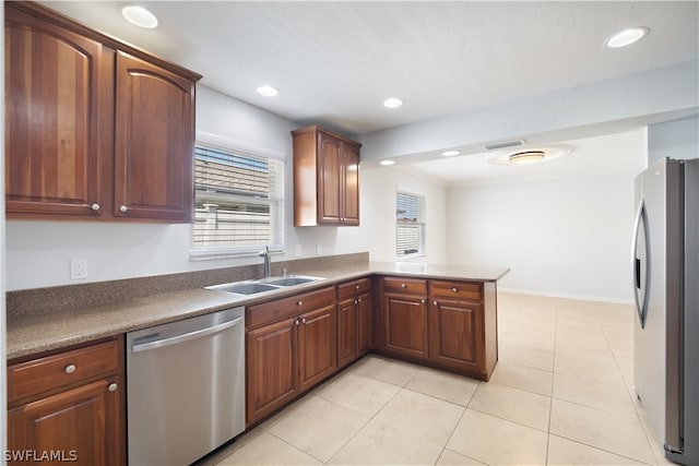 kitchen featuring sink, kitchen peninsula, light tile floors, and appliances with stainless steel finishes