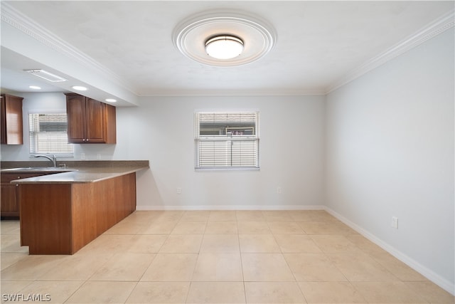 kitchen featuring sink, crown molding, and light tile flooring