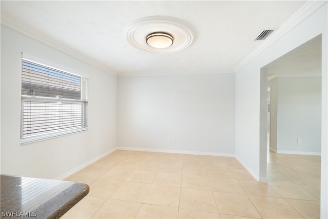 empty room with crown molding and light tile floors