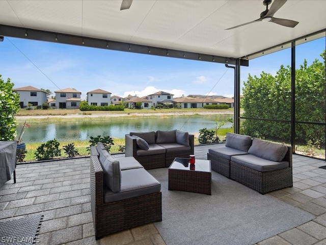 view of patio with ceiling fan, an outdoor living space, and a water view