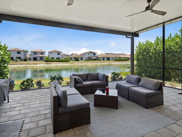 view of patio with a water view, an outdoor living space, and ceiling fan