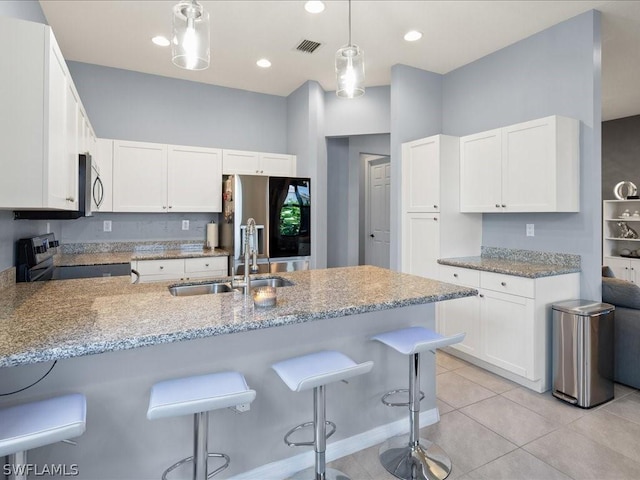 kitchen featuring a kitchen breakfast bar, white cabinetry, sink, and stainless steel appliances