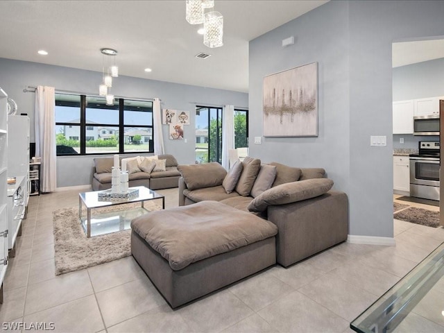 living room featuring a wealth of natural light, a chandelier, and light tile patterned flooring