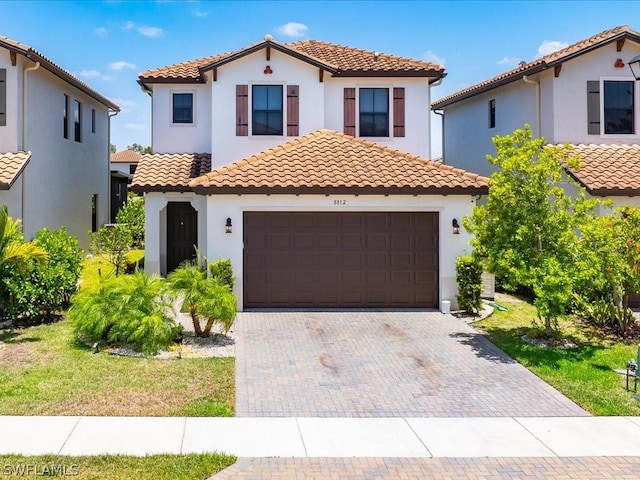 mediterranean / spanish-style house featuring a front lawn and a garage