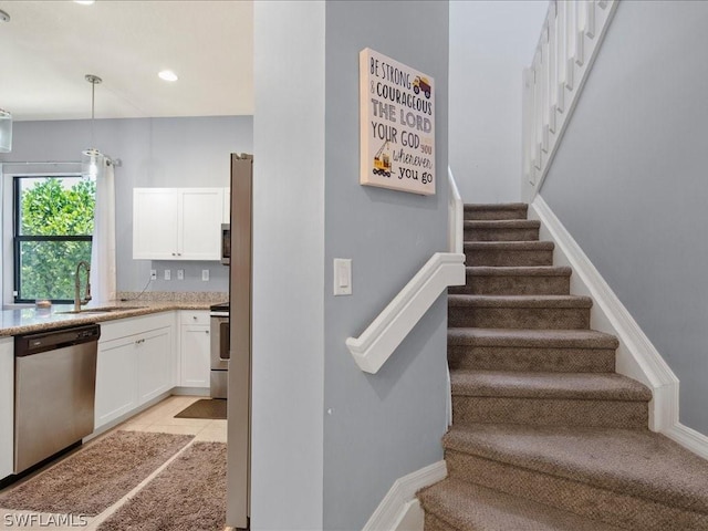 stairway with sink and tile patterned flooring