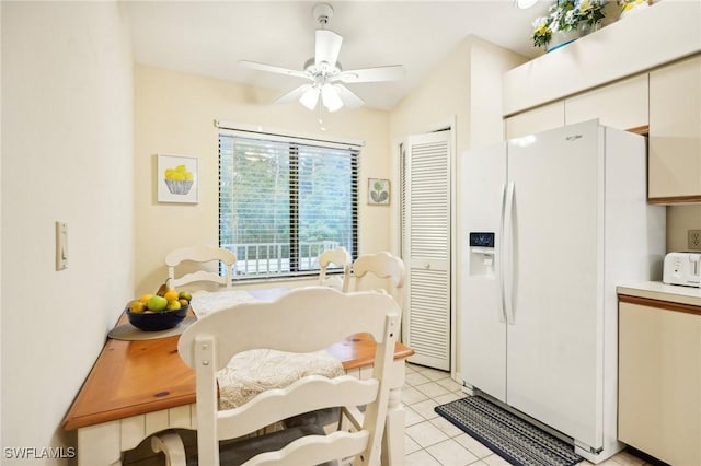 kitchen with ceiling fan, white fridge with ice dispenser, and light tile patterned floors