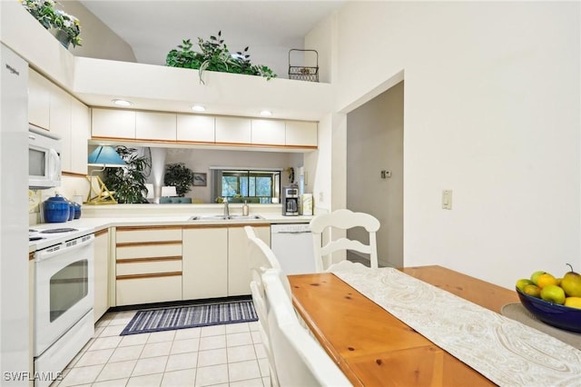 kitchen featuring white appliances, sink, and light tile patterned floors