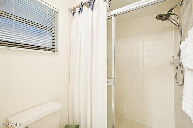 bathroom with a shower with curtain and toilet