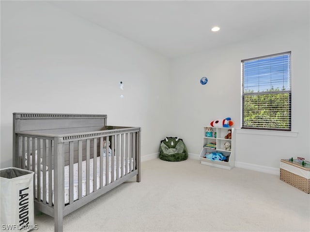 carpeted bedroom with a nursery area