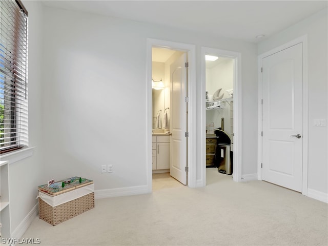 bedroom featuring light colored carpet and ensuite bath