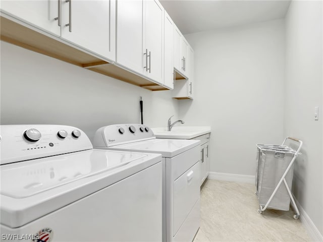 laundry area featuring sink, washing machine and clothes dryer, light tile floors, and cabinets