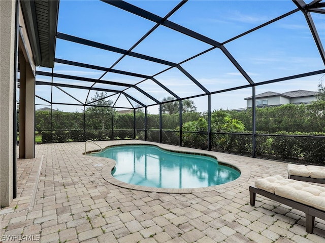 view of pool with a patio and glass enclosure