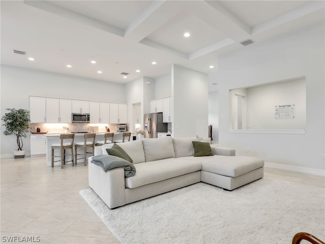 living room featuring beam ceiling, coffered ceiling, and light tile floors