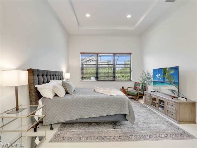 bedroom with carpet and a raised ceiling