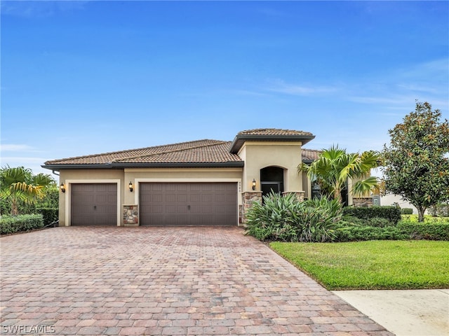 mediterranean / spanish-style house featuring a garage and a front lawn