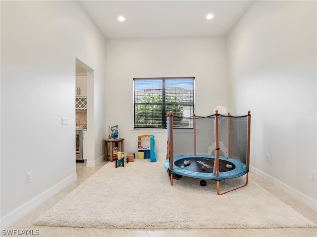 sitting room featuring wine cooler and light tile floors