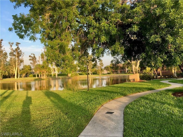 view of home's community featuring a water view and a lawn