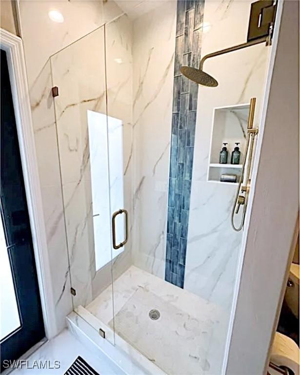 full bath with a marble finish shower