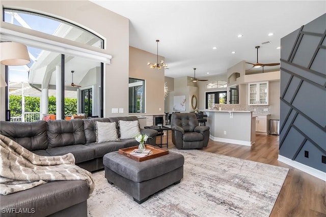 living area featuring recessed lighting, light wood-style flooring, visible vents, and ceiling fan with notable chandelier