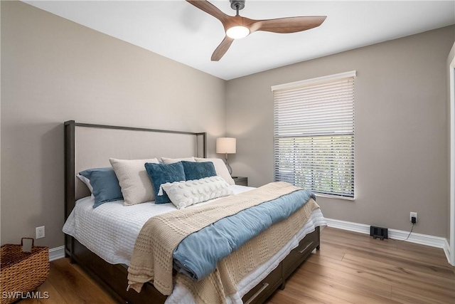 bedroom featuring ceiling fan, wood finished floors, and baseboards