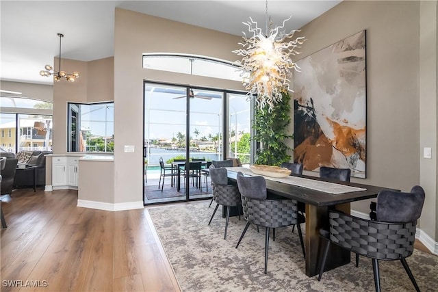 dining room with a chandelier, wood finished floors, and baseboards