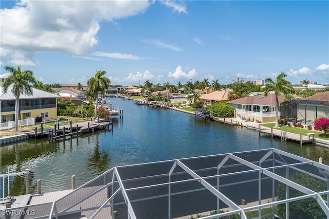 view of dock with a lanai, a water view, and a residential view