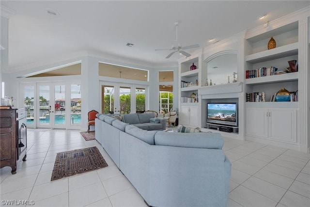 living room with french doors, built in features, ceiling fan, and light tile patterned flooring