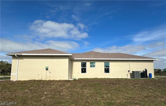 view of side of property featuring a yard and central AC