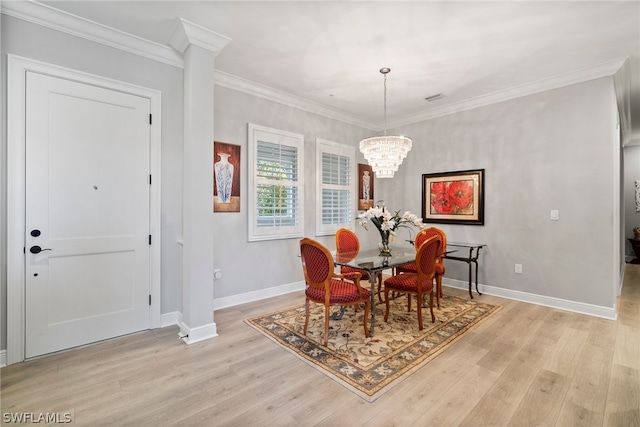 dining area featuring an inviting chandelier, crown molding, and light wood-type flooring