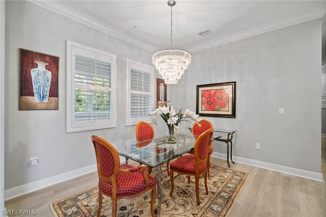 dining area featuring light hardwood / wood-style flooring, a chandelier, and crown molding