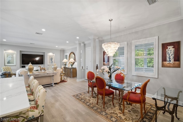 dining room with a chandelier, crown molding, and light hardwood / wood-style flooring