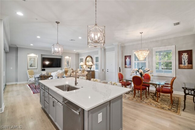 kitchen featuring pendant lighting, light wood-type flooring, a center island with sink, sink, and dishwasher