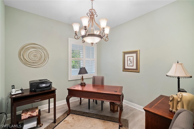 office space featuring light wood-type flooring and an inviting chandelier