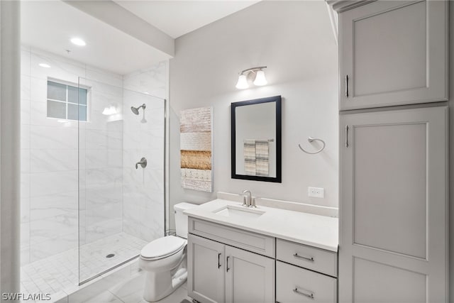 bathroom featuring a shower with door, vanity, toilet, and tile flooring