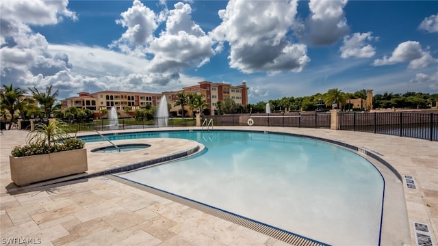 view of pool with a hot tub and a patio