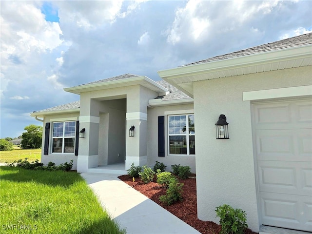 property entrance featuring a yard and a garage