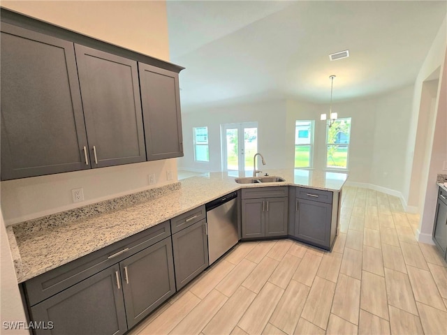 kitchen featuring light stone countertops, sink, dishwasher, kitchen peninsula, and a notable chandelier