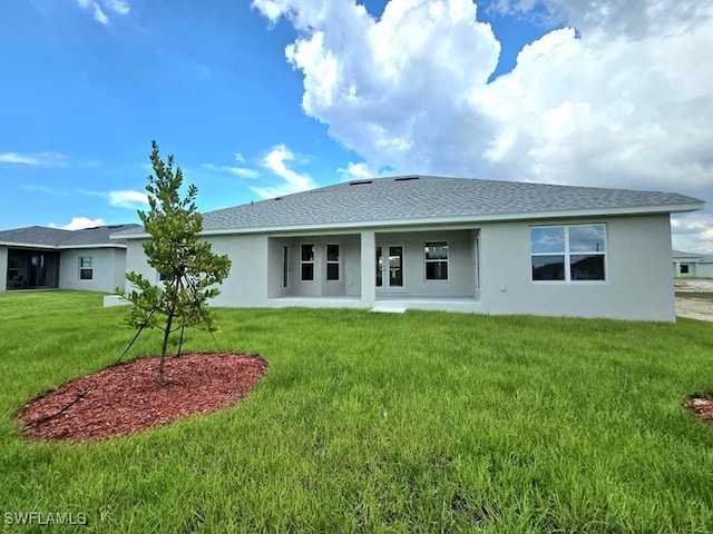 rear view of house featuring a yard