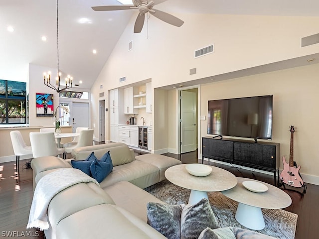 living room with high vaulted ceiling, dark wood-type flooring, wine cooler, and ceiling fan with notable chandelier