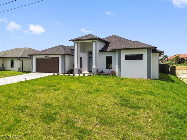 prairie-style house featuring a garage and a front lawn