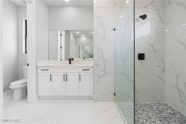 bathroom with vanity, tiled shower, and toilet