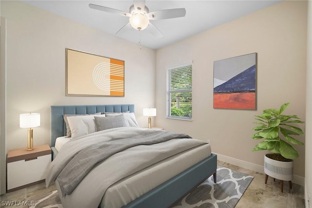 bedroom with ceiling fan and baseboards