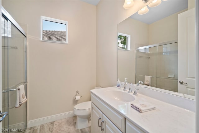 bathroom with tile patterned flooring, toilet, vanity, baseboards, and a stall shower