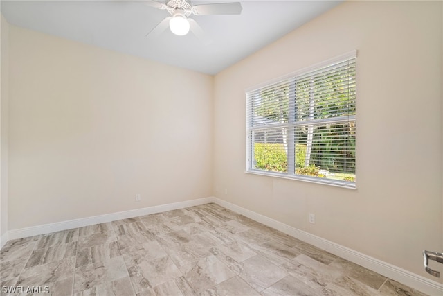 spare room featuring ceiling fan and baseboards