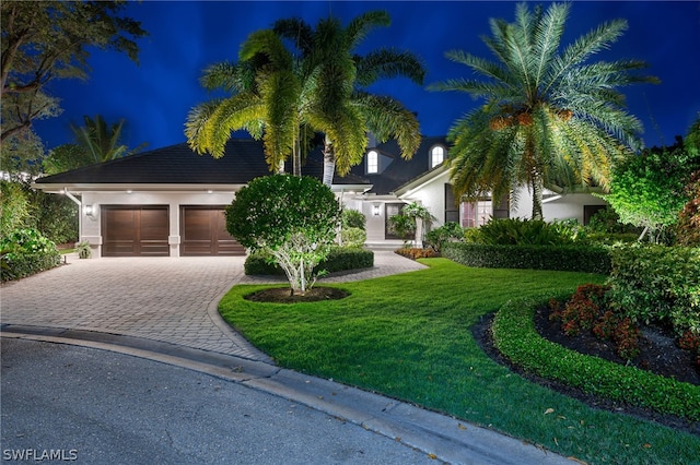 view of property hidden behind natural elements with a yard and a garage