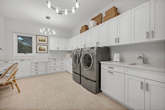 clothes washing area featuring cabinets, light tile patterned floors, washer and clothes dryer, and sink