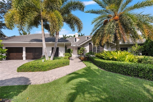 view of front of home with a front yard and a garage